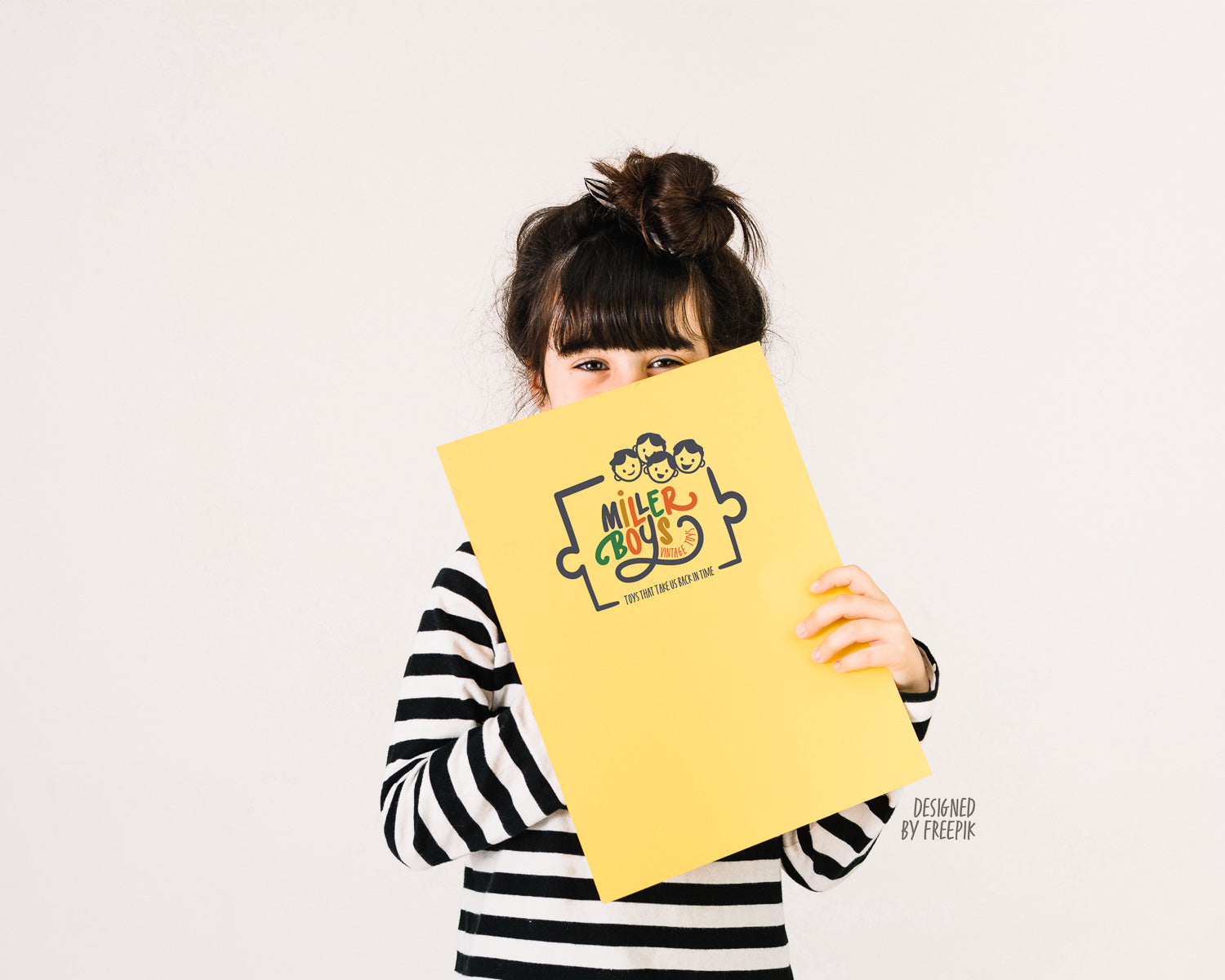 A girl holding a large piece of yellow paper with the Miller Boys Vintage Toys Logo on it.