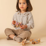 Girl playing with wooden airplanes.