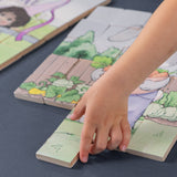 A child's hand putting a wooden piece of a puzzle together.