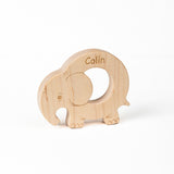 A wooden elephant-shaped teether with the name 'Colin' engraved on it.