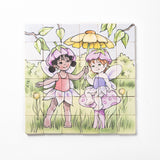 A completed magnetic wooden puzzle depicting two fairies in a garden setting, with interlocking pieces.