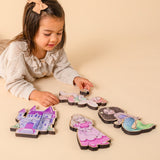A girl lying on the floor completing a set of puzzles with a fairytale theme.