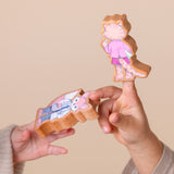Children's hands playing with wooden finger puppets.