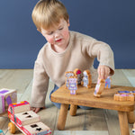 Boy playing with Finger Puppets on a small wooden stool.