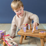 Boy playing with Finger Puppets on a small wooden stool.