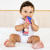 Baby holding a small American flag with 'U.S.A.' text on a white background
