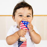 Baby holding a small American flag-shaped object against a white background