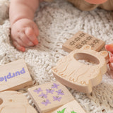 Baby's hand reaching for wooden teether and blocks.