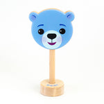 A wooden rattle with a blue bear face, a long wooden dowel for grasping, and a small base with the word "bear" spelled out. 