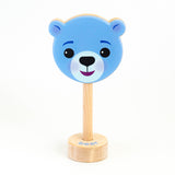 A wooden rattle with a blue bear face, a long wooden dowel for grasping, and a small base with the word "bear" spelled out. 