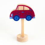 A wooden rattle with a car top, a long wooden dowel for grasping and a small base with the word "car" spelled out. 