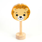 A wooden rattle with a lion face, a long wooden dowel for grasping and a small base with the word "lion" spelled out. 