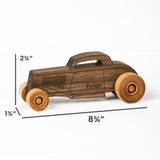 A wooden toy car with a dark brown wood grain finish and lighter natural wood wheels, shown with dimension lines indicating its height of 2 3/4 inches, width of 8 3/4 inches, and depth of 1 3/4 inches on a white background.