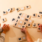 A brother and sister spelling out words with the Montessori-inspired learning tiles.