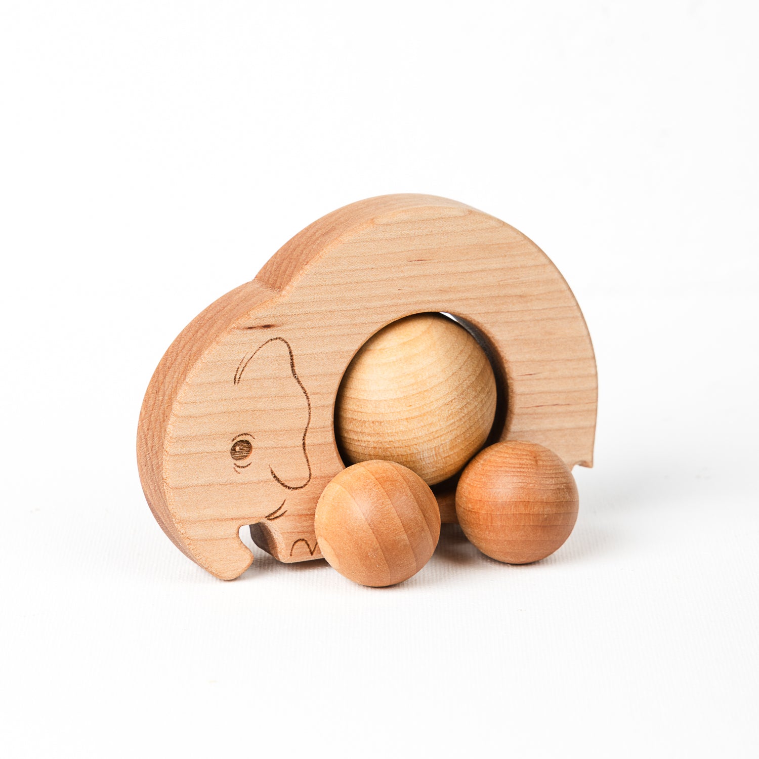 A wooden elephant push toy with a large textured sphere wheel and two smaller balls, set against a white background.