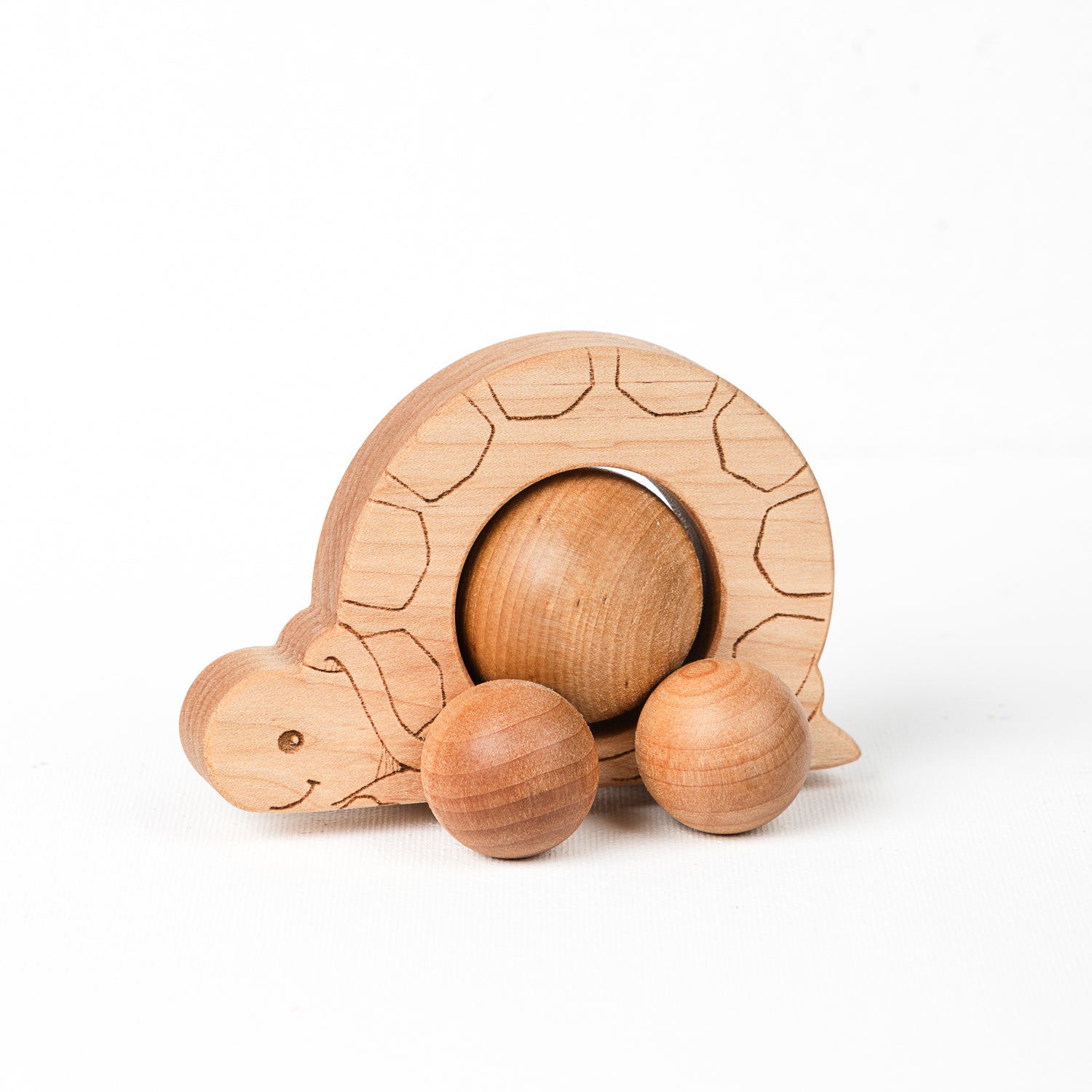 A wooden turtle push toy with a large textured sphere wheel and two smaller textured wheels, set against a white background.