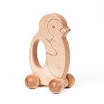 Wooden penguin-shaped push toy with large textured sphere wheels.