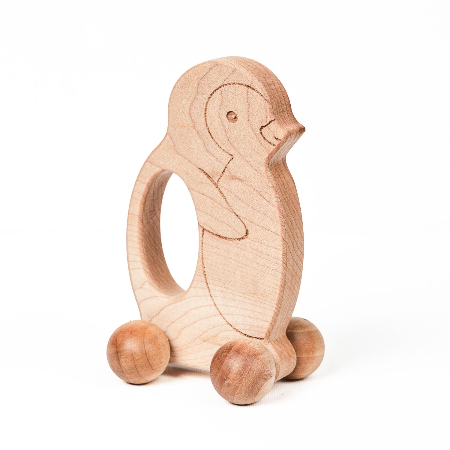 Wooden penguin-shaped push toy with large textured sphere wheels.