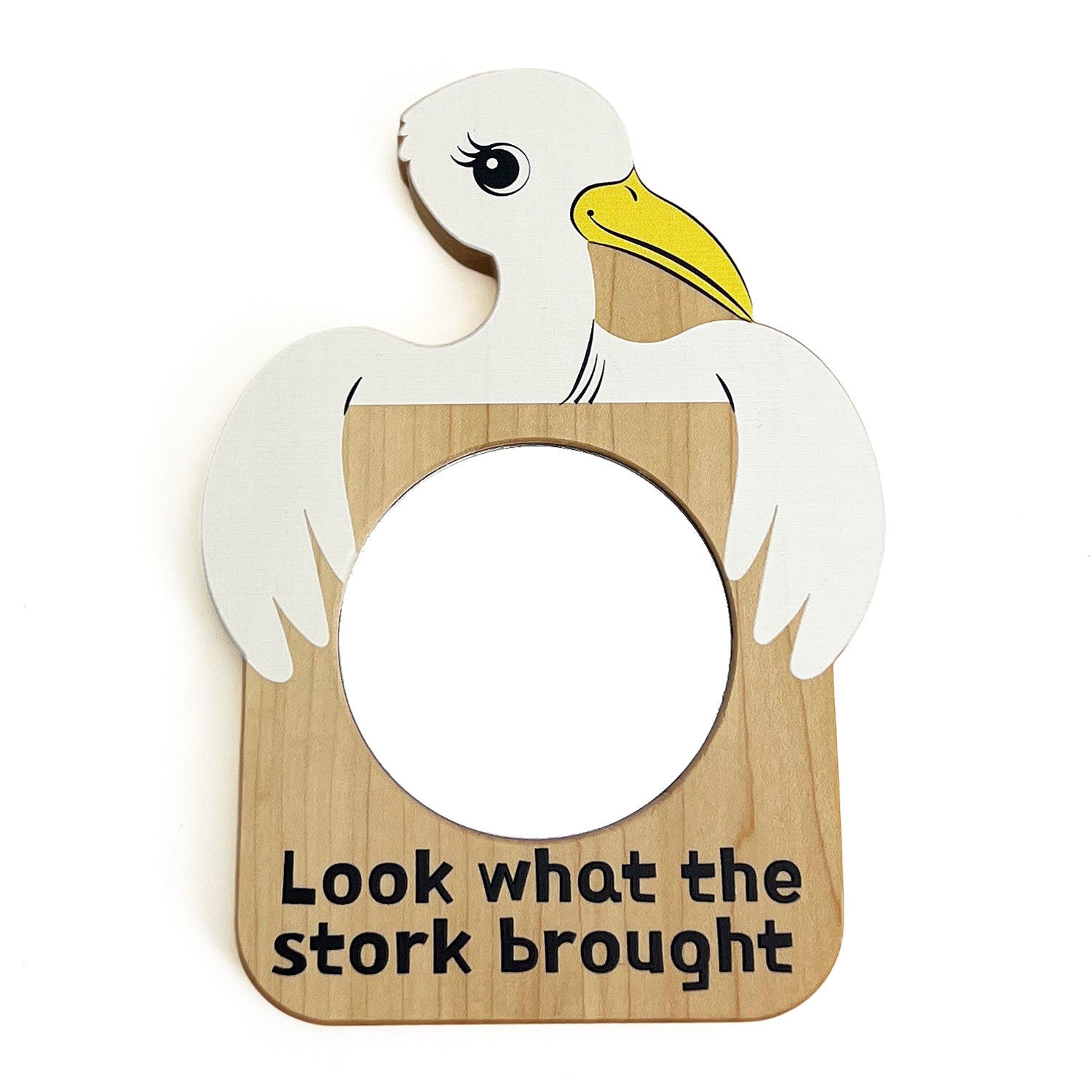 A white stork with yellow beak holding a circular mirror with "Look what the stork brought" written in black lettering across the bottom.