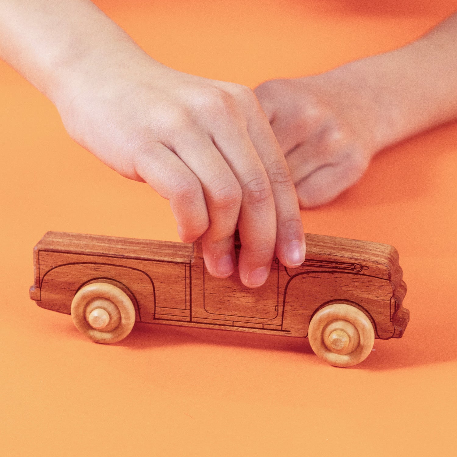 Child playing with wooden pick up truck.