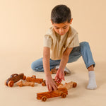 Boy playing with wooden cars and trucks.