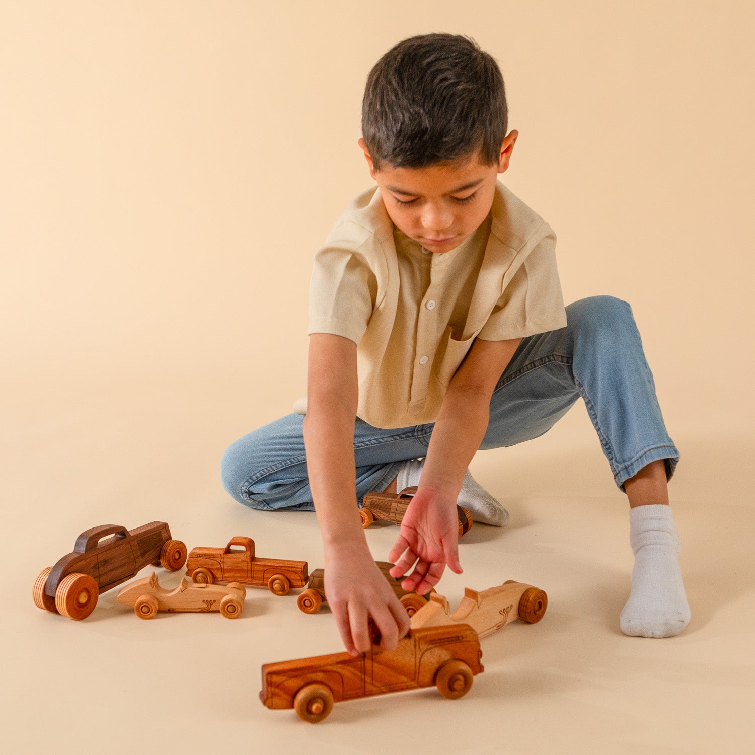Boy playing with wooden cars and trucks.