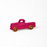 Small 1950s pink dyed pickup truck.