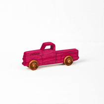 Small 1950s pink dyed pickup truck.