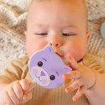 A baby holding a cat rattle.