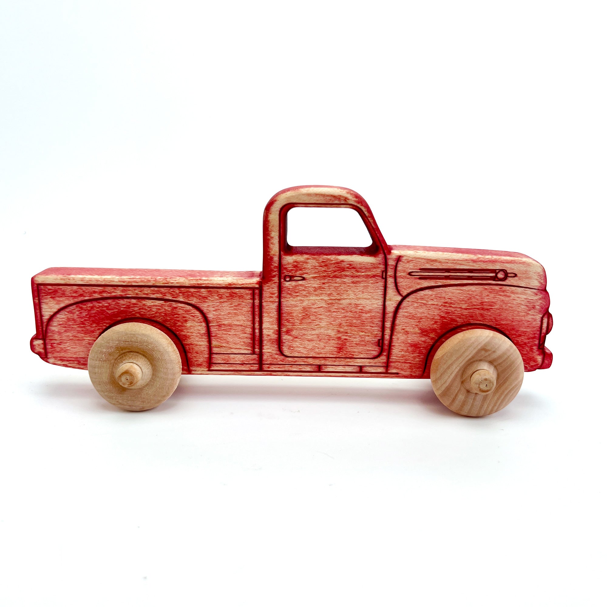 A wooden toy pickup truck with a red-painted body and natural light wood wheels, shown in profile against a plain white background.