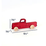 A small red wooden toy pickup truck with natural wood wheels, shown on a white background with dimension lines and text indicating 1 3/4 inches height, 1 3/4 inches width, and 5 1/2 inches length.
