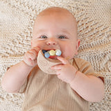 Baby lying on his back with Moon Silicone Teether in his mouth.