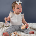A baby playing with wooden silicone teethers. 