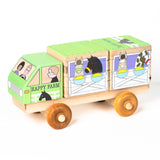 A wooden 3D puzzle truck resembling a horse trailer with colorful animal illustrations on each block, mounted on wooden wheels.