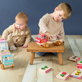 Boy and baby playing with stackable wooden trucks.
