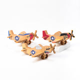 A set of three hand-carved wooden airplanes with classic P-51 Mustang designs, featuring vibrant colors and propellers.