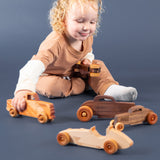 Child playing with several different wooden vehicles.