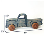 A small wooden toy pickup truck with a distressed blue-gray painted finish and natural brown wood wheels, shown on a white background with dimension lines indicating 9 inches long, 3 3/4 inches high, and 2 1/4 inches deep.