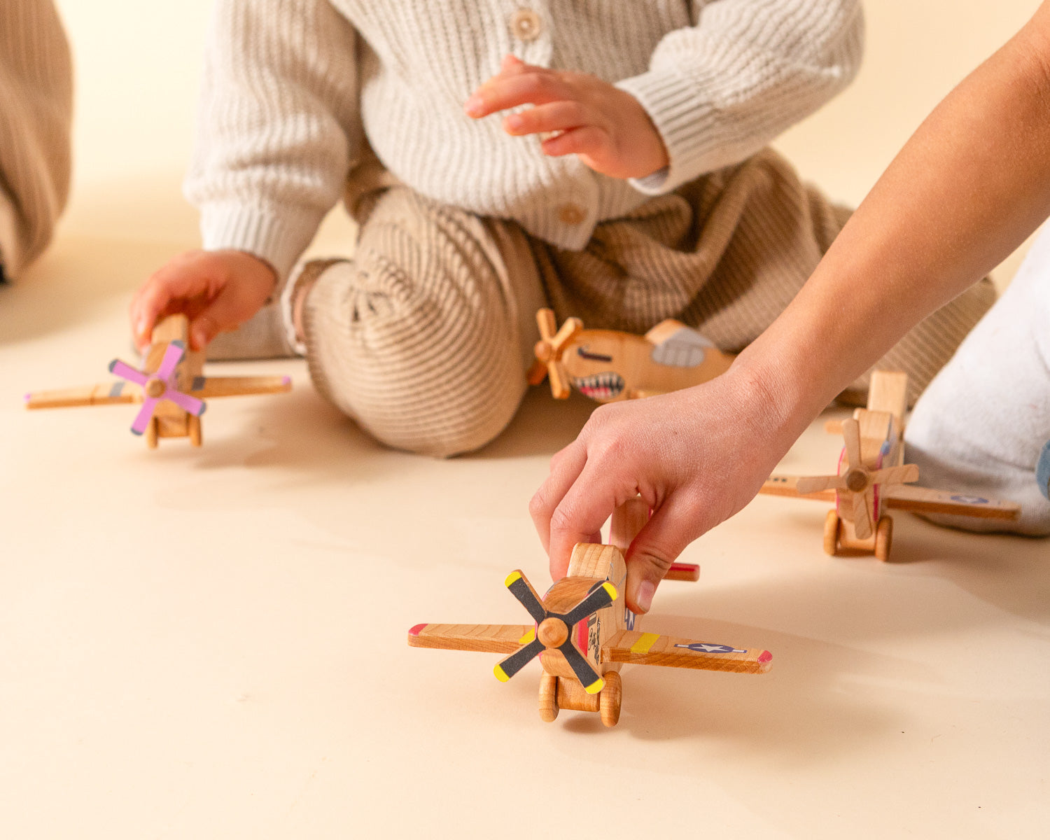 Children playing with wooden airplanes.