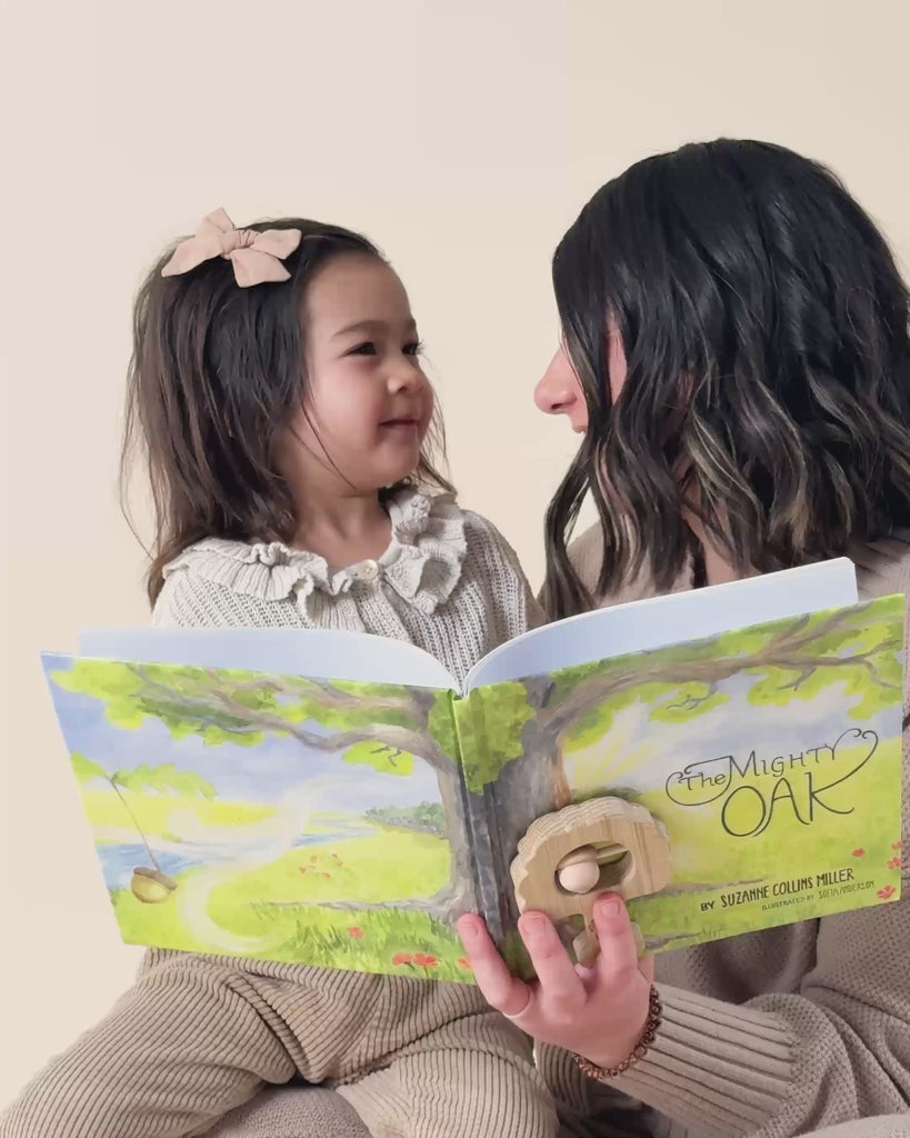 A mom reading The Mighty Oak book to her daughter. 