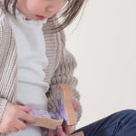 A girl playing with wooden finger puppets.