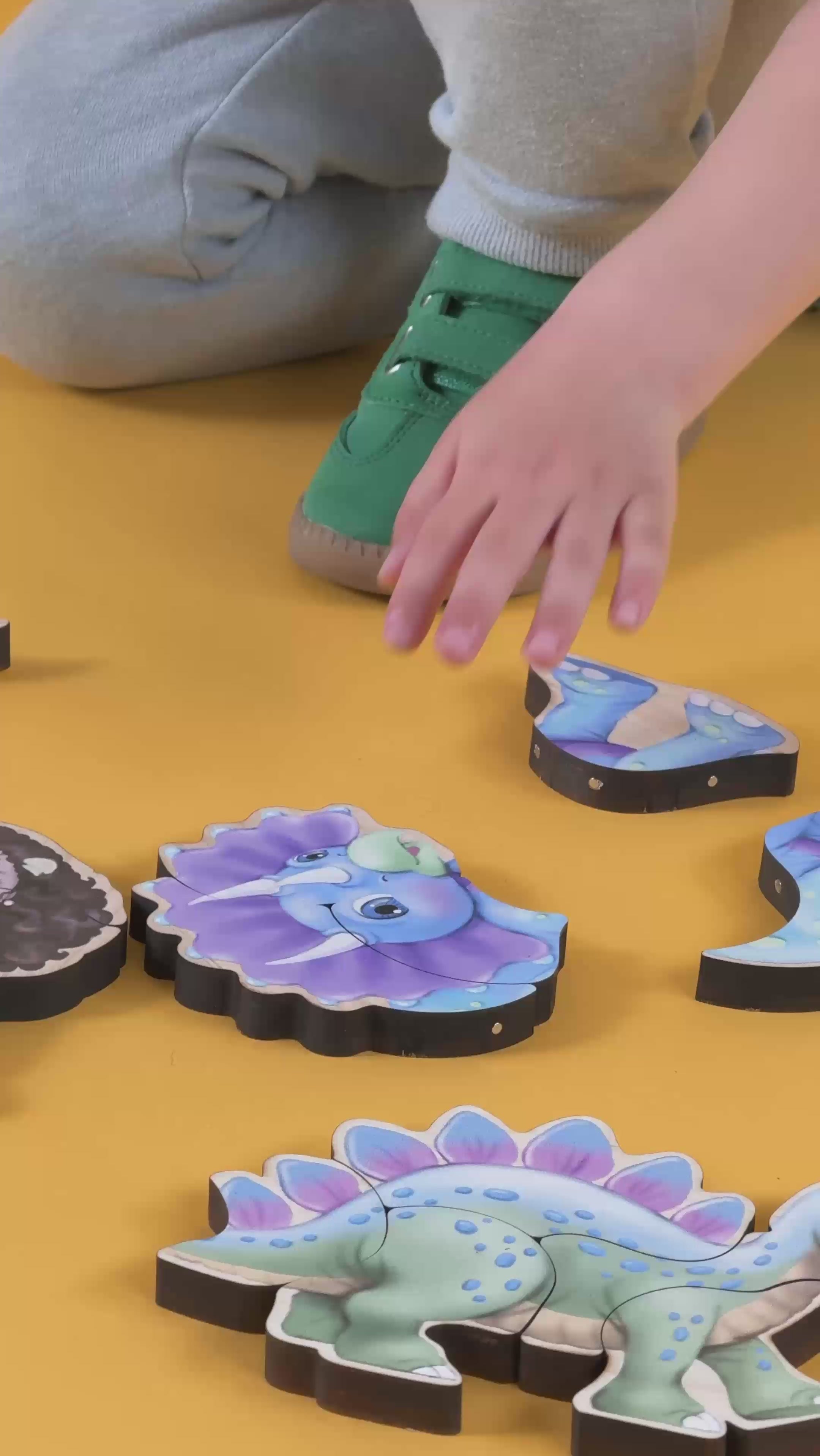 A boy making a puzzle of a triceratops with magnetic pieces.