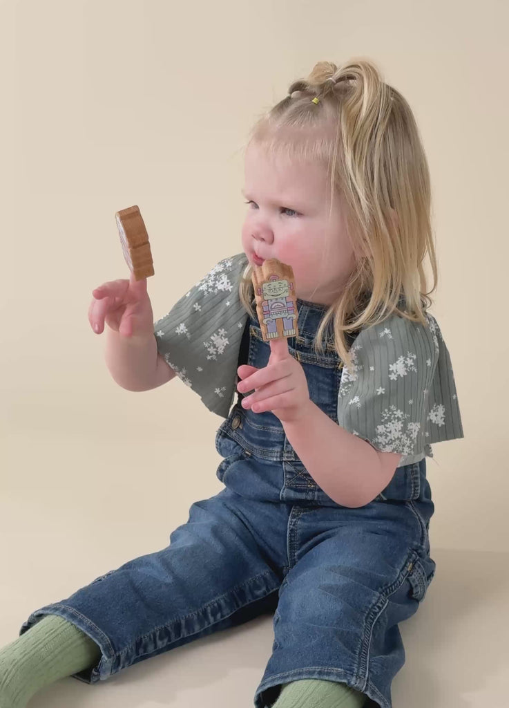 A girl pretend playing with wooden robot finger puppets.