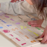 A little girl and her brother playing with Montessori inspired learning tiles with numerals, symbols and colors.