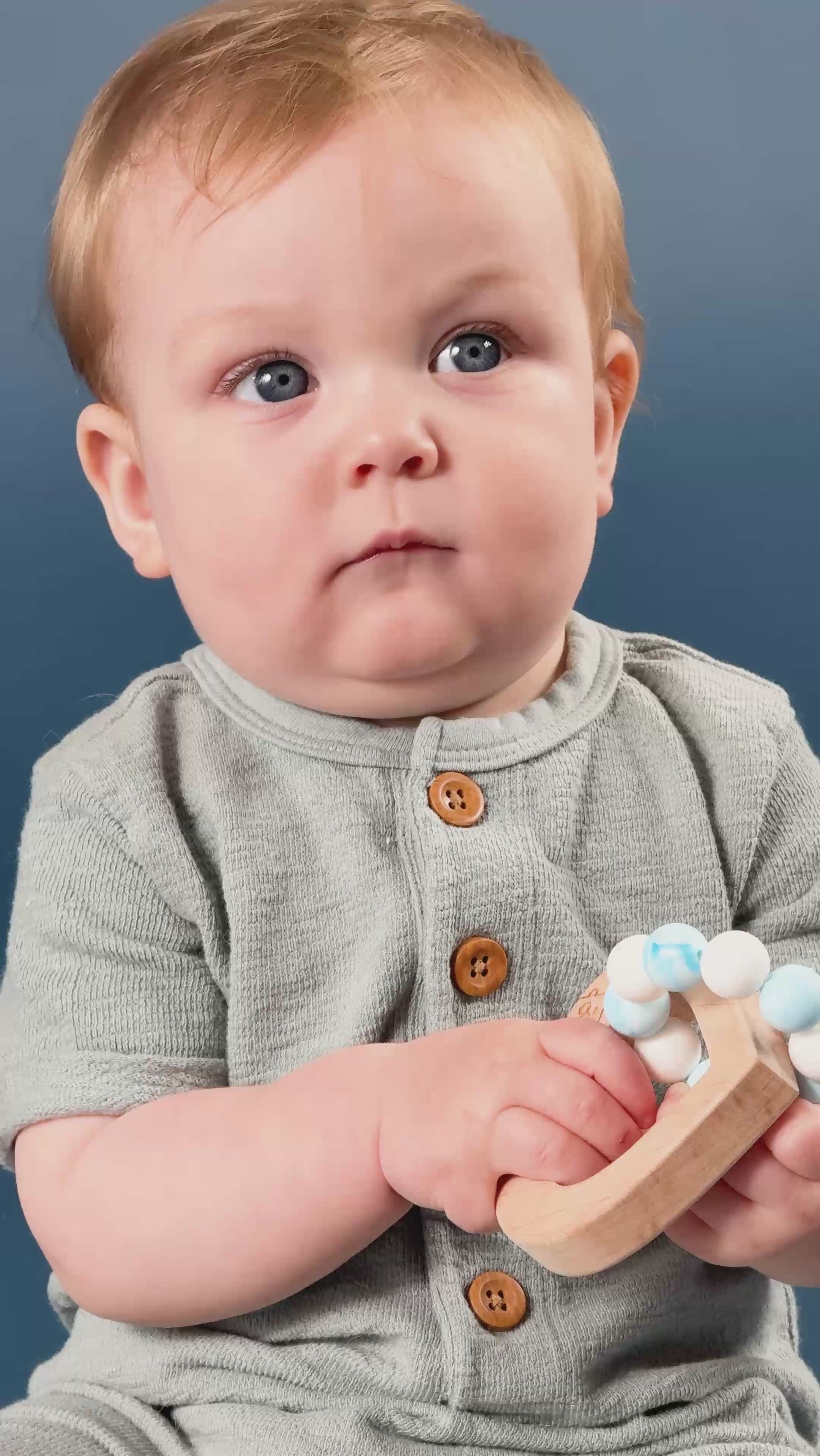 An adorable baby with a wooden and silicone heart teether. 