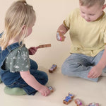 A brother and sister pretend playing with wooden finger puppets. 