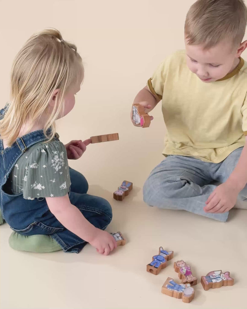 A brother and sister pretend playing with wooden finger puppets. 